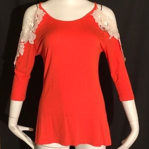Orange top with crochet/lace sleeves.